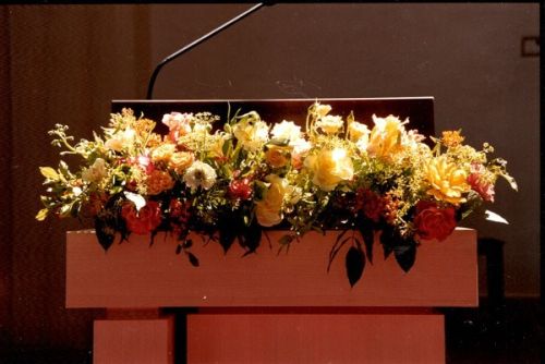 lectern decorated with yellow and peach flower garland,Françoise Weeks